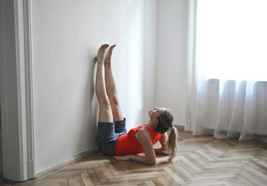 Fitness revolution with a woman doing Pilates with the support of a wall